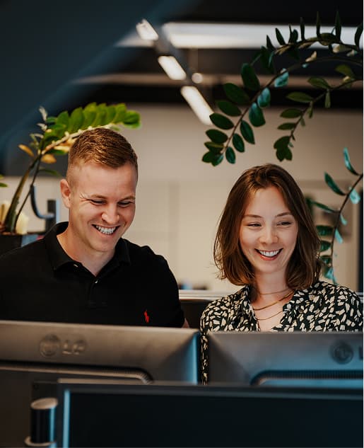 Zwei Mitarbeitende bei konzentrierter Teamarbeit im modernen MUUUH!-Büro