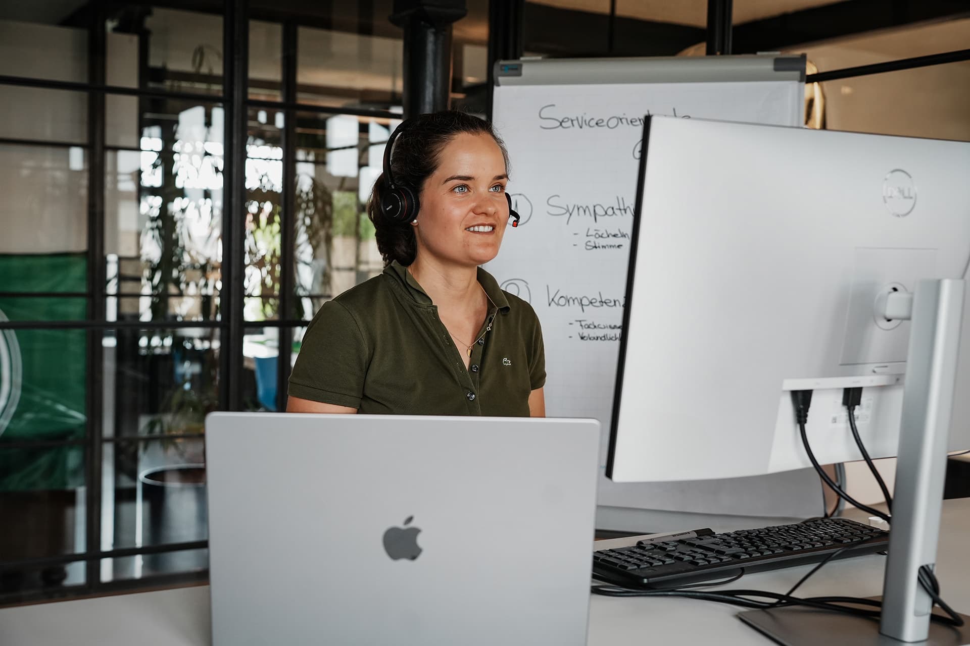 Charlotte Arnoldi arbeitet am Laptop in einem modernen Büroumfeld