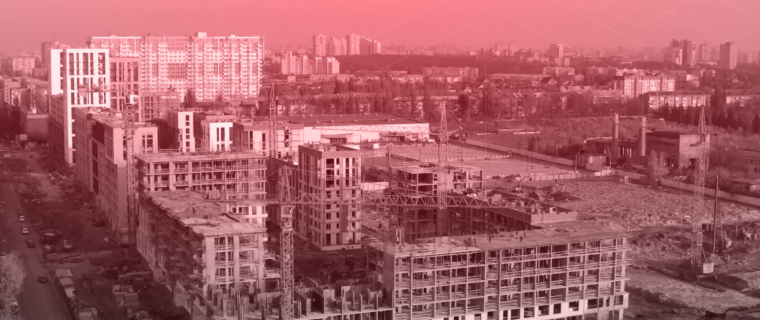 Stadtlandschaft mit Gebäuden im Rohbau und Abriss unter rosa-getöntem Himmel