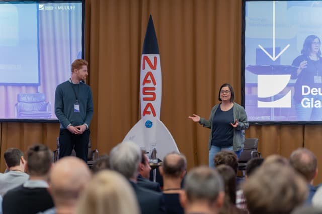 Präsentation beim Muuuh!nwalk 2026 mit NASA-Rakete als Bühnenrequisite vor Publikum