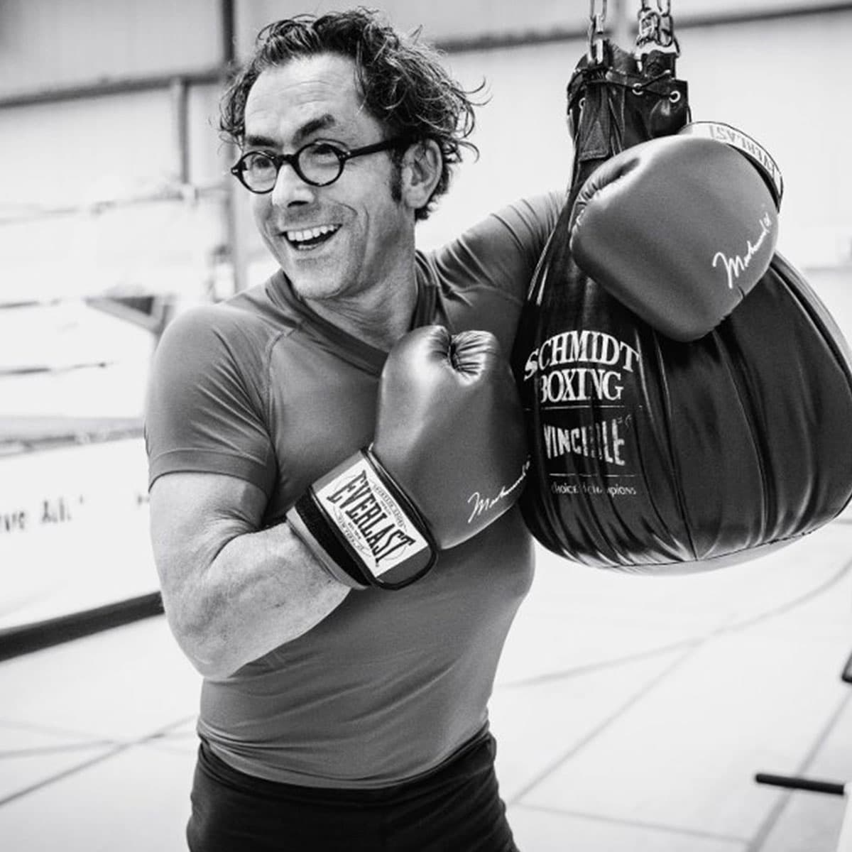 Jens Bormann, Gründer und Geschäftsführer von MUUUH!, mit Boxhandschuhen und Sandsack im Schwarzweißporträt