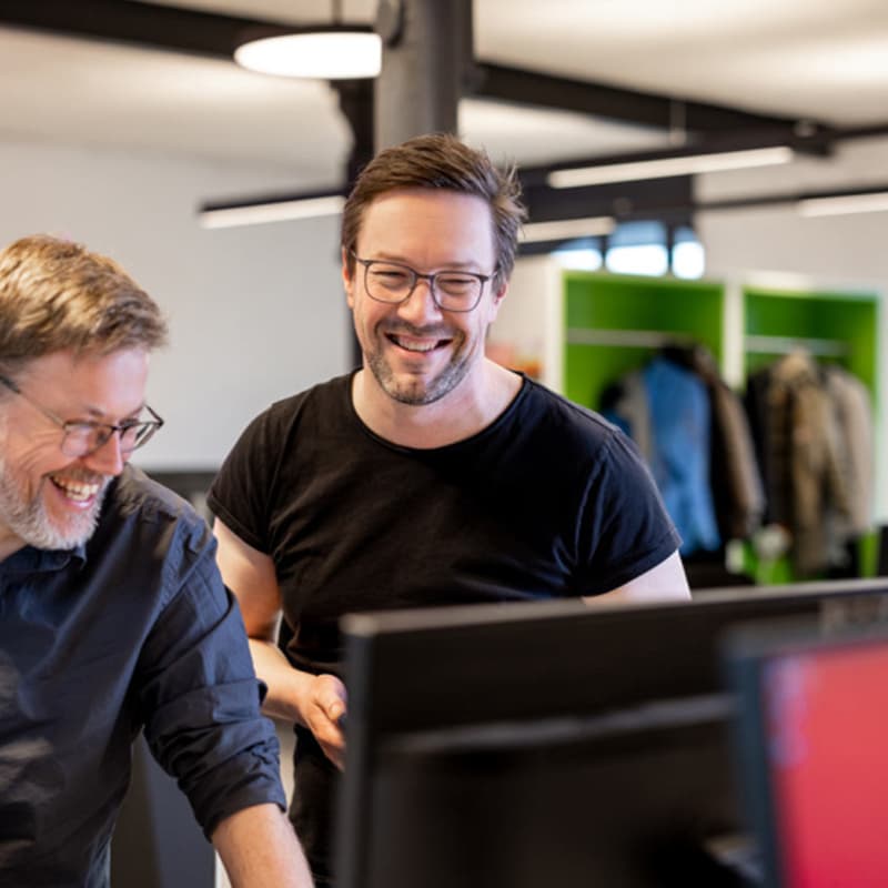 Dirk Kolhosser, Executive Creative Director bei MUUUH!, im Gespräch mit einem Kollegen