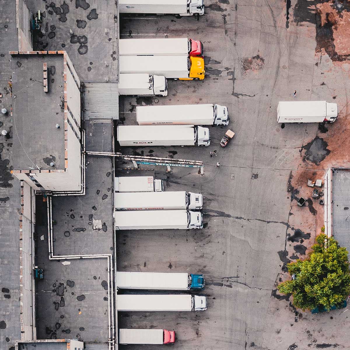 Luftaufnahme eines Logistik-Terminals mit mehreren Lkw an Laderampen