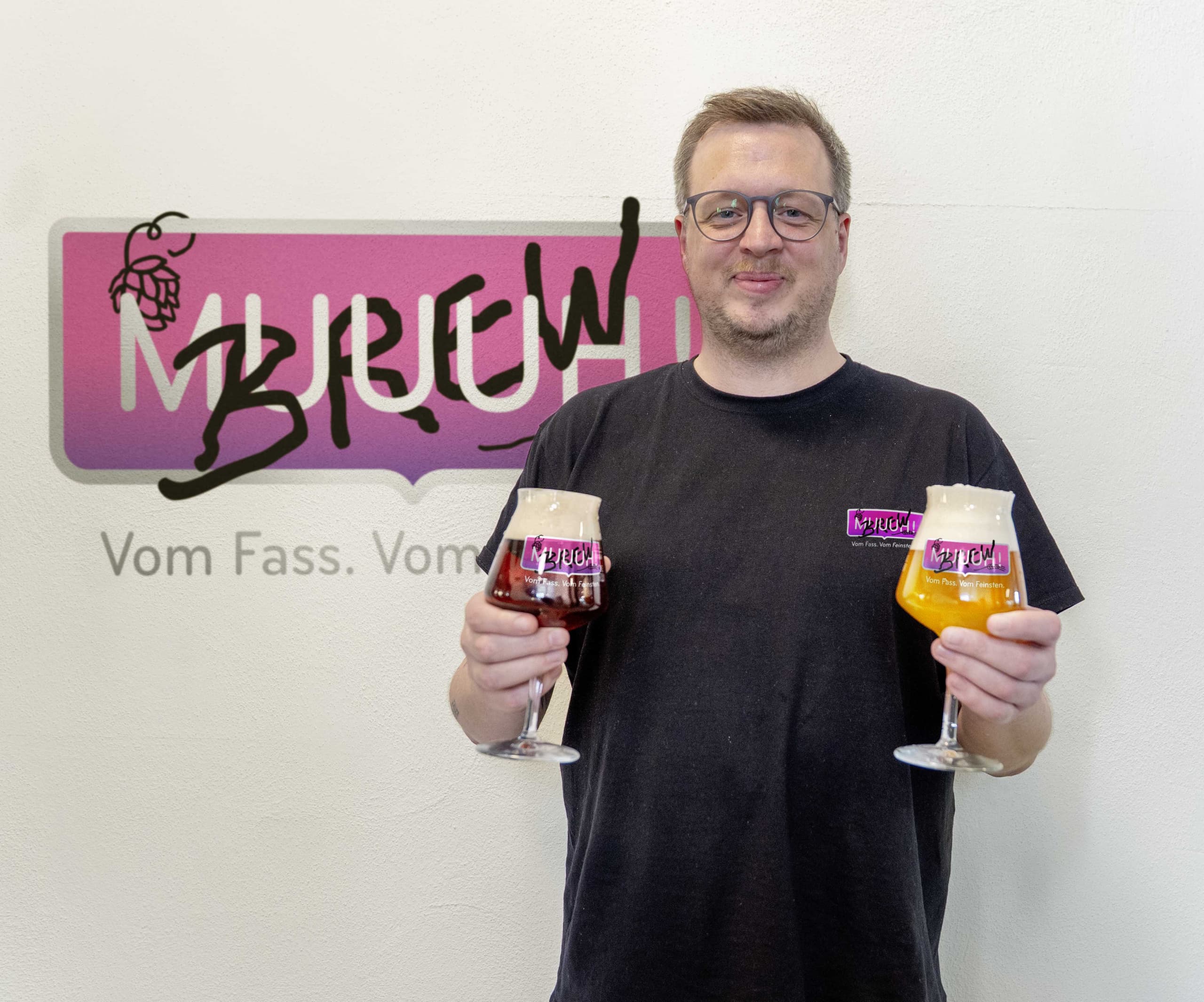John mit zwei Biergläsern vor dem MUUUHBrew-Logo