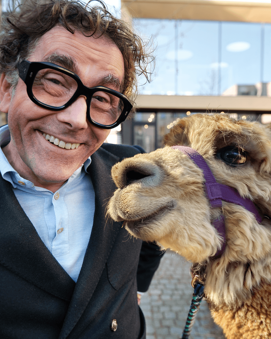 Jens Bormann macht Selfie mit einem Alpaka im Innenhof der MUUUH! Group