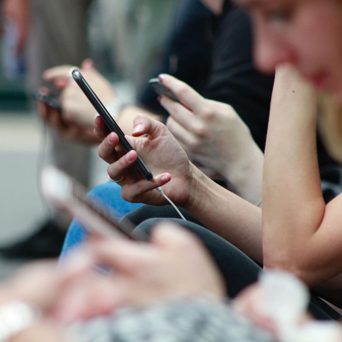 Mehrere Personen nutzen Smartphones für WhatsApp-basierte Kundenkommunikation