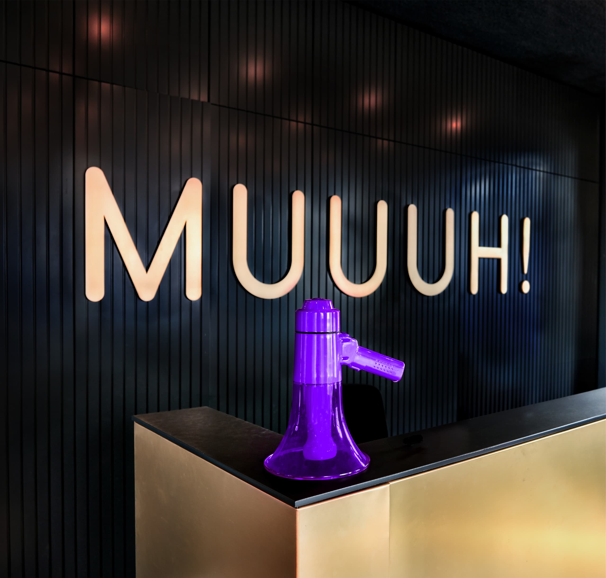 Titelbild der MUUUH! Voice Studie 2026: lila Megafon vor dem beleuchteten MUUUH!-Schriftzug an dunkler Wand