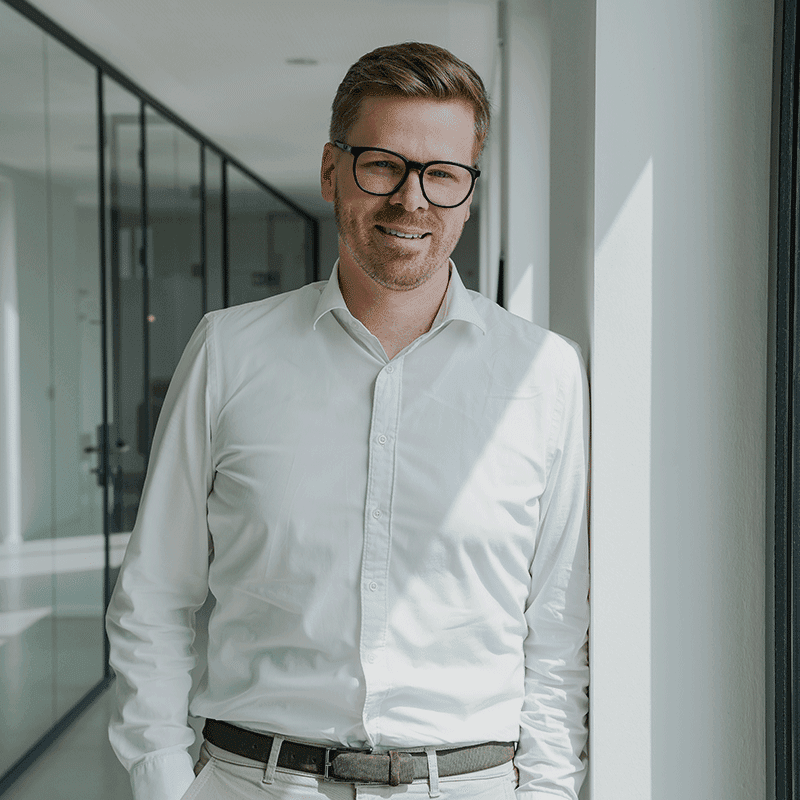 Daniel Hoffstädt, Senior Manager bei MUUUH!, lächelt in einem modernen Büroflur