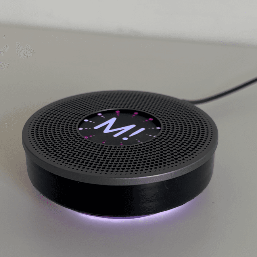 Runder schwarzer Smart-Speaker mit leuchtendem MUUUH!-Logo und pinkem Lichtring – der fiktive 'Muuuhtivator' KI-Assistent