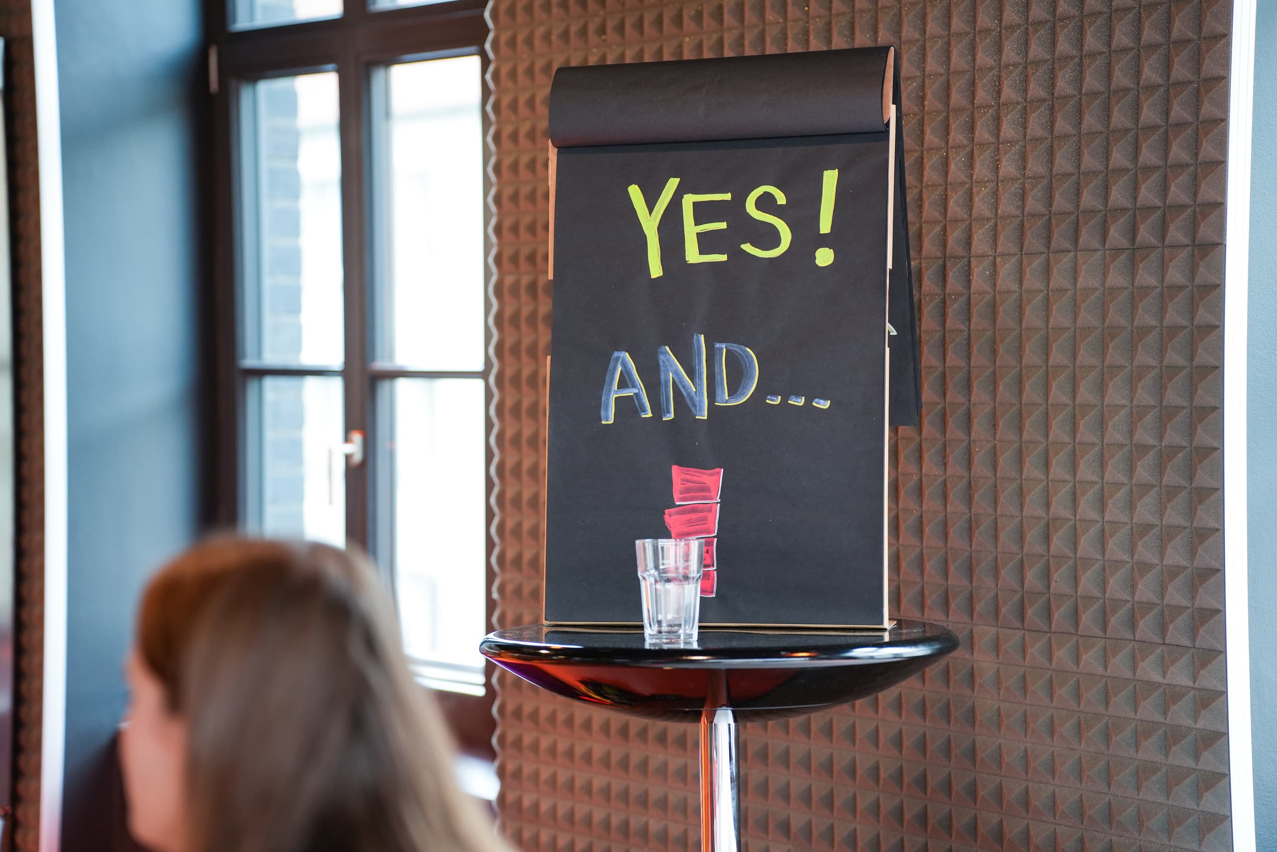 Tafel mit den Worten 'YES!' und 'AND...' in bunter Kreide – Symbol für eine offene, bejahende Haltung im Change-Prozess