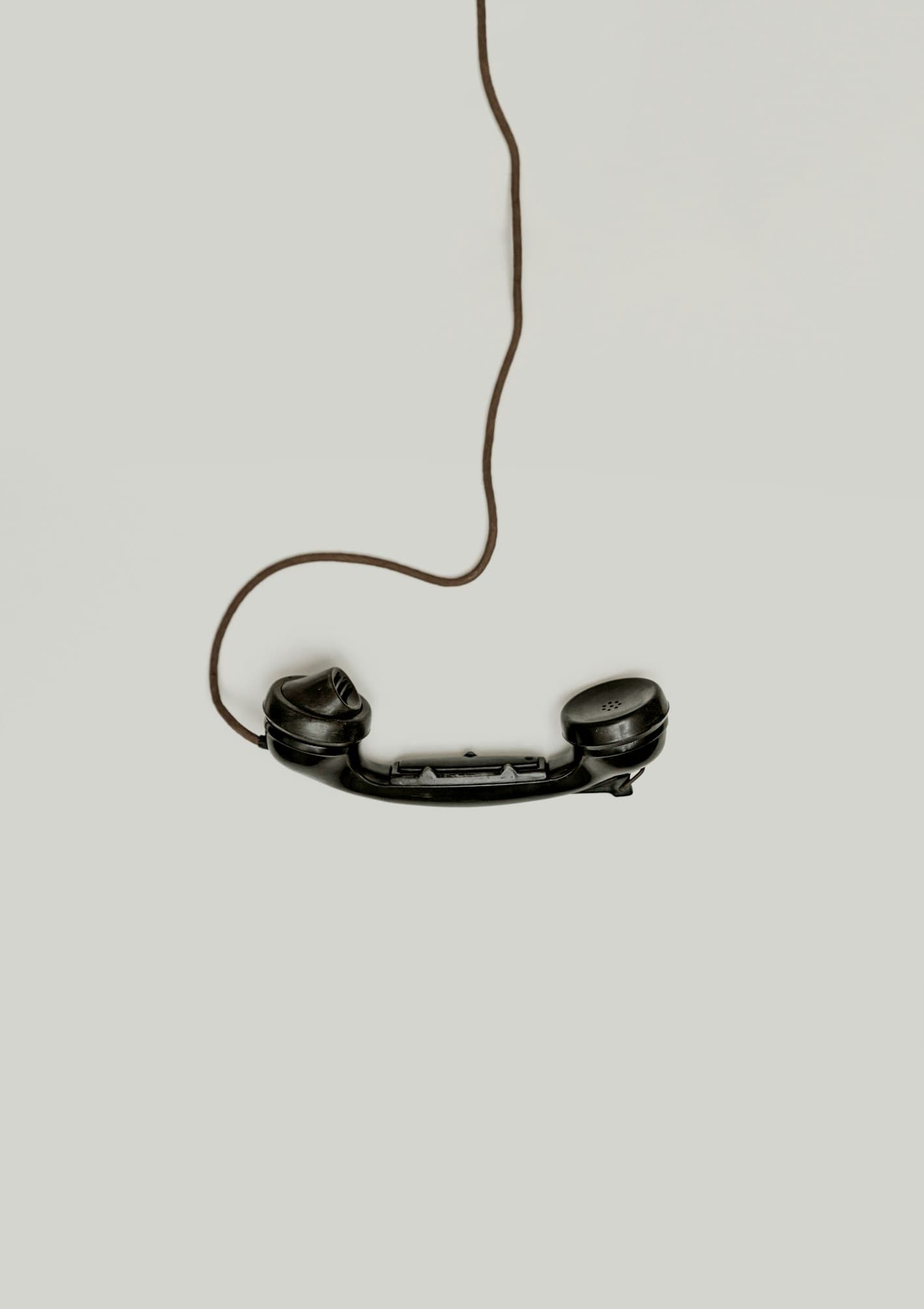 Schwarzer Telefonhörer hängt an einem Kabel – Symbol für telefonischen Kundenkontakt im Cloud Contact Center