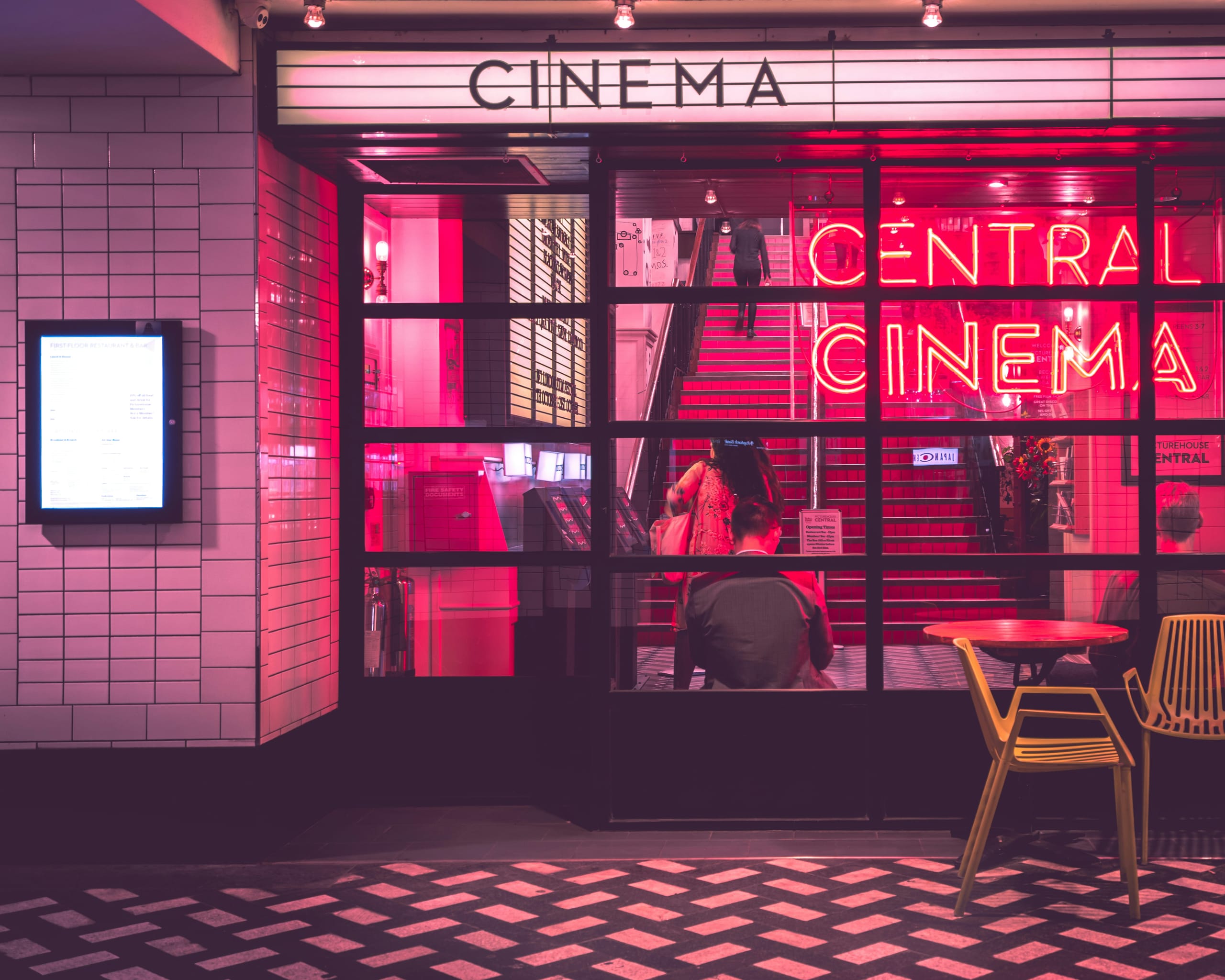 Moderner Kino-Eingang mit rosa Neonbeleuchtung – Symbolbild für die Kino-Branche