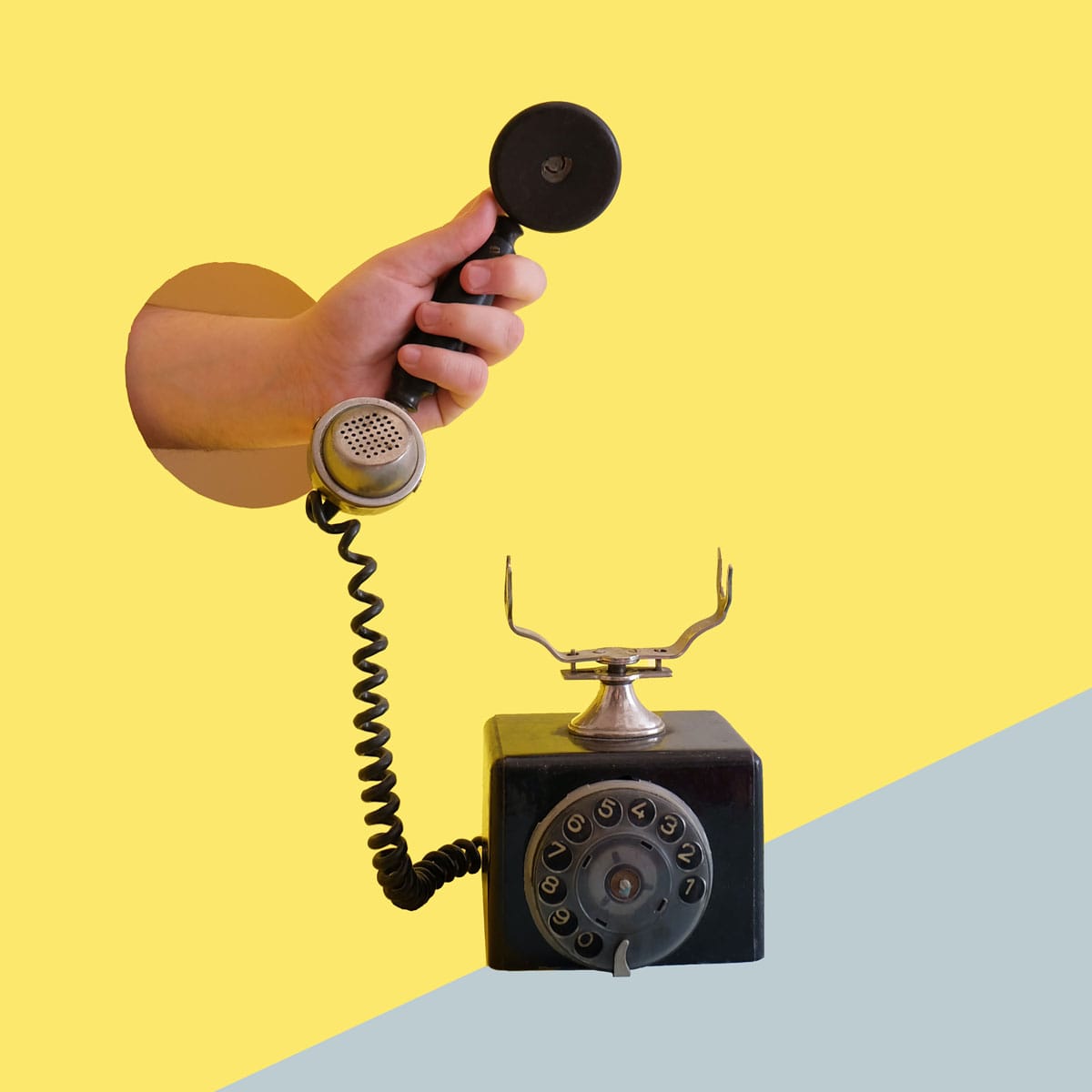 Hand hält Telefonhörer eines alten Wählscheibentelefons – symbolisch für IVR 2.0 und sprachgesteuertes Telefonie-Routing