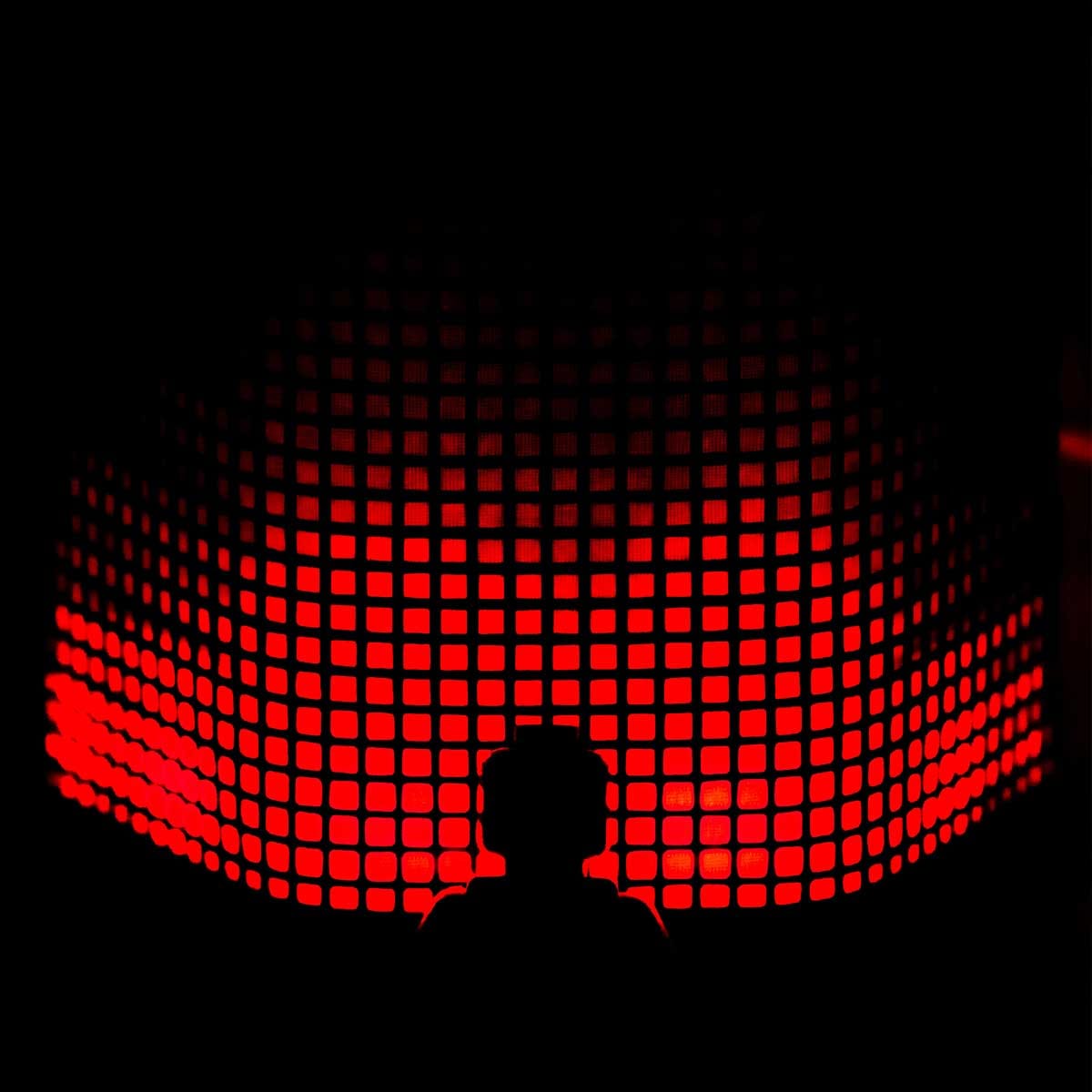 Silhouette einer Person vor einer rot leuchtenden Pixel-Wand als Sinnbild für Hidden Champions im Daten-Marketing