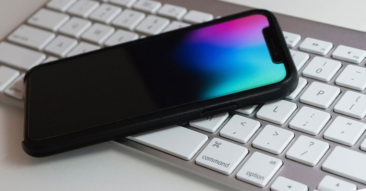 Smartphone liegt auf Computer Tastatur