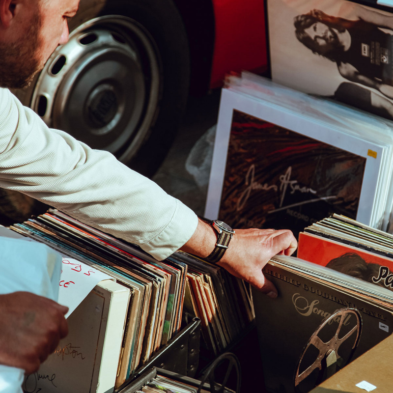Mann schaut sich Vinyl Platten aus einer Sammlung an