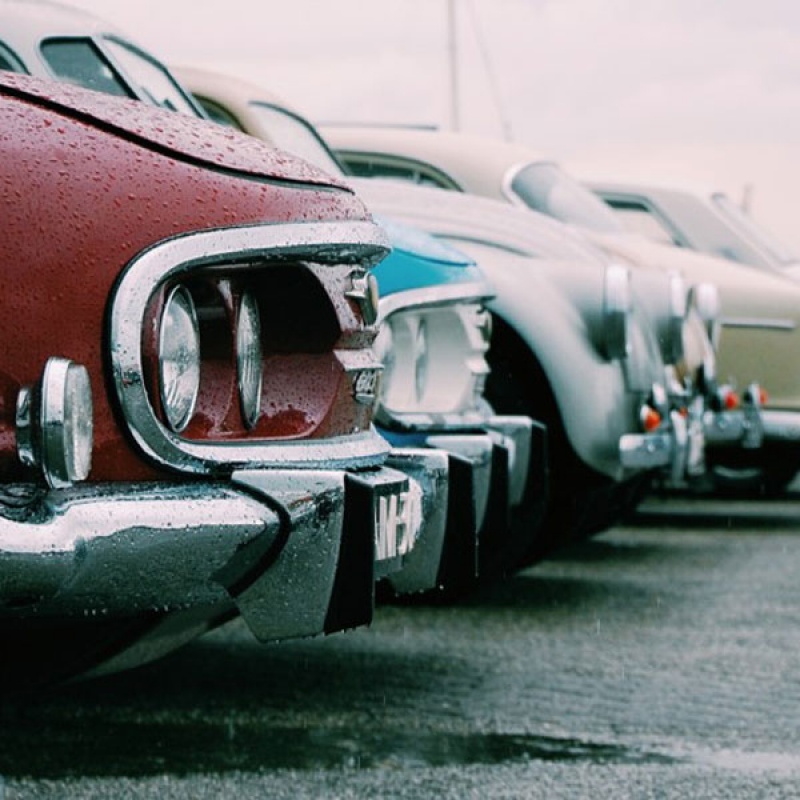 Rote und blaue Oldtimer Autos auf einem Parkplatz