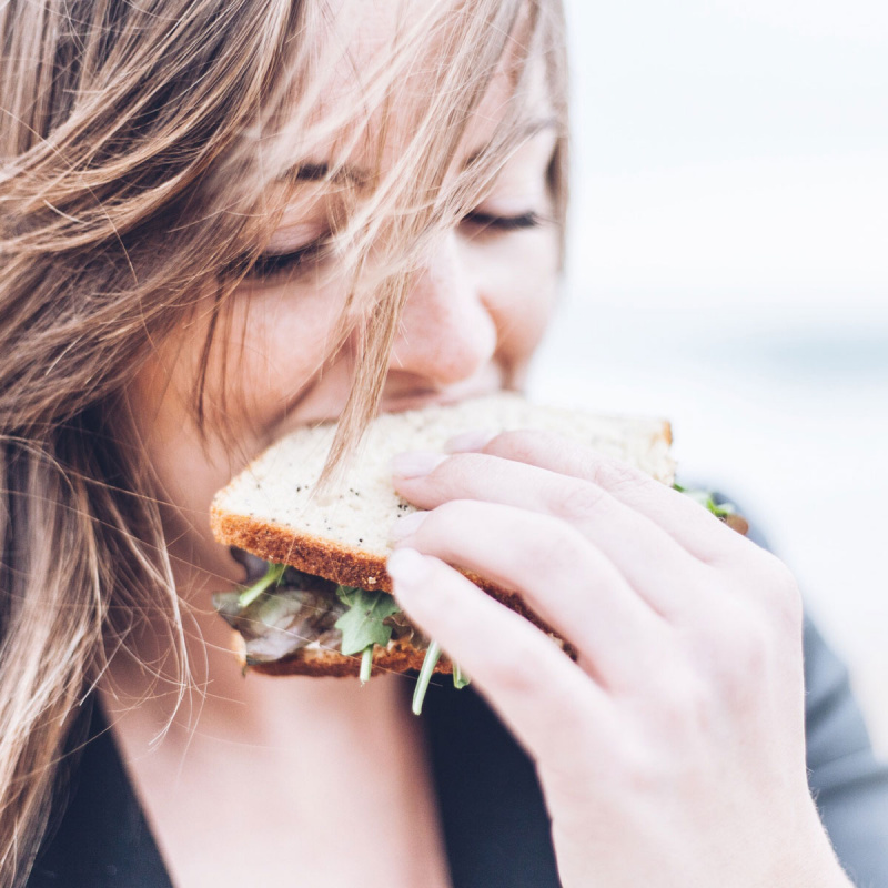 Eine junge Frau isst ein Sandwich