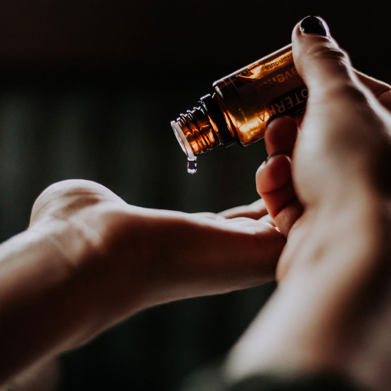 Eine Frau tropft etwas aus einer Flasche auf ihre Hand