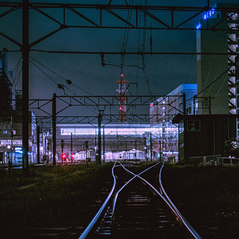 Bahngleise einer Großstadt im Neonlicht