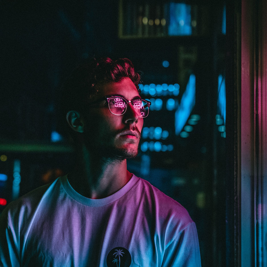 Junger Mann mit Hipster Brille im Neonlicht