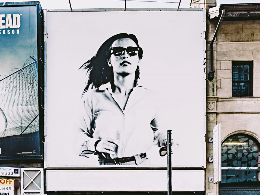 Billboad mit rennender Frau mit Sonnenbrille
