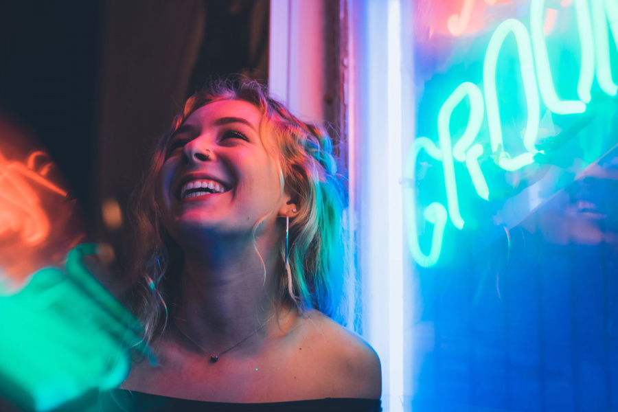 Junge Frau vor Neon Leuchtreklame