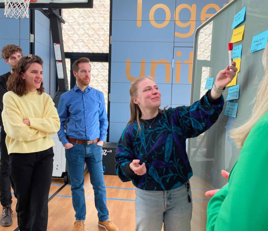 Group of people looking at a whiteboard with post-its.